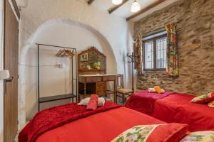 a bedroom with two red beds and a mirror at Posada De Santiago in Rubite