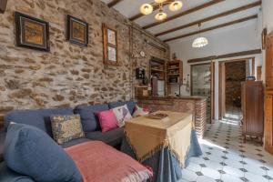 a living room with a blue couch and a stone wall at Posada De Santiago in Rubite
