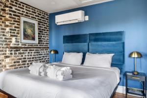 a bedroom with blue walls and a bed with white sheets at King Suite 4th Floor Downtown Hotel Boutique in Savannah