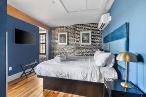 a bedroom with a bed and a brick wall at King Suite 4th Floor Downtown Hotel Boutique in Savannah