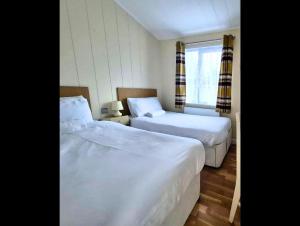 a hotel room with two beds and a window at Bella Mere Lodge in West Down