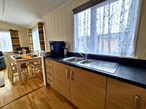a kitchen with a sink and a large window at Bella Mere Lodge in West Down