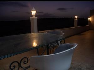 a table and chairs on a balcony at night at Le mirage in Tozeur +7 photos