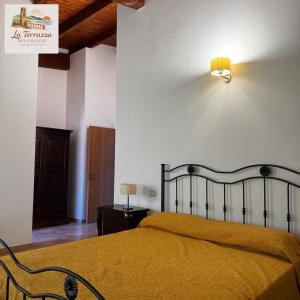 a bedroom with a bed with a yellow blanket at La terrazza del cilento in Perito