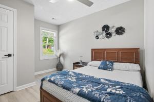 a bedroom with a bed with a blue comforter and a window at Elegant Modern Ranch Home in Atlanta