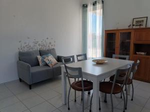 a living room with a table and chairs and a couch at Casa Tamerici in Marcelli +13 photos