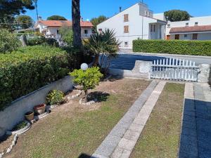 a garden with a white fence and some plants at Casa Tamerici in Marcelli