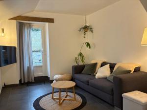 a living room with a couch and a table at Clécy Chouette maison atypique centre in Clécy