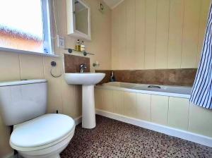 a bathroom with a toilet and a sink and a tub at Bella Mere Lodge in West Down +31 photos
