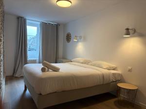a bedroom with a large bed and a window at Clécy Chouette maison atypique centre in Clécy