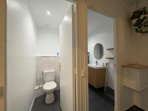 a white bathroom with a toilet and a sink at Clécy Chouette maison atypique centre in Clécy +22 photos