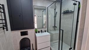 a bathroom with a sink and a glass shower at Sunset Apartment Aktau Квартира в центре у моря in Aktau +45 photos