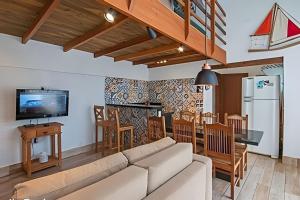 a living room with a couch and a table and a kitchen at Jungle Beach Maresias in Maresias