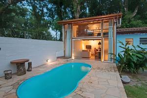 a large blue pool in front of a house at Jungle Beach Maresias in Maresias