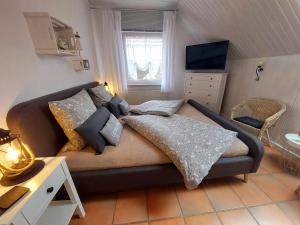 a bedroom with a couch with pillows and a television at Ferienwohnungen Naheliebe in Bärenbach
