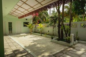 a courtyard of a house with trees and plants at Ari Paradise in Hangnaameedhoo