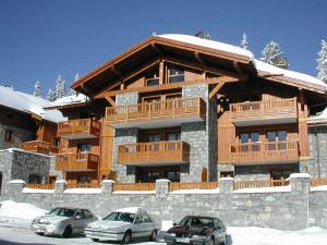 a large building with cars parked in front of it at Appartement 3 pièces Sud avec balcon, parking et proche pistes et commerces - FR-1-398-571 in La Rosière +4 photos