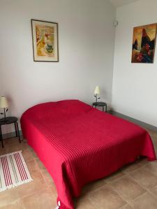 a red bed in a white room with two tables at Orangerie in Benais +7 photos