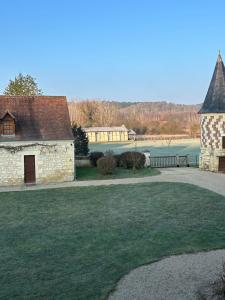 an old stone building with a grass yard at Orangerie in Benais