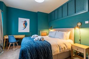 a bedroom with a king sized bed with blue walls at Dairy Green Flat in Shifnal