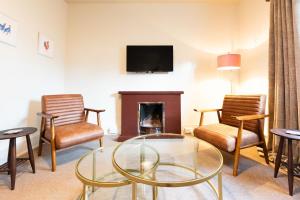 a living room with a fireplace and a tv at Dairy Green Flat in Shifnal
