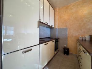 a kitchen with white cabinets and a refrigerator at Przno Sea Pearl - Seaview Holiday apartment in Pržno +8 photos