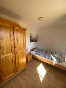 a bedroom with a bed and a wooden cabinet at M1 Appartement in Uttenweiler