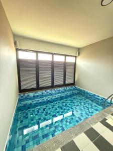 a swimming pool with blue tiles in a room at Walnut Grove Premium Pool Villa in Batu Caves