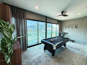 a pool table in a room with a large window at Walnut Grove Premium Pool Villa in Batu Caves