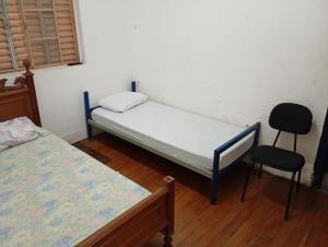 a room with two beds and a chair in it at Hotel Kairós in Campinas