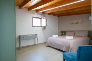 a bedroom with a bed and a table and a window at La Casa Sotto il Campanile in Sciacca