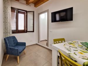 a room with a table and a chair and a television at La Casa Sotto il Campanile in Sciacca