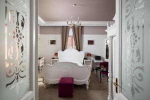 a living room with a white chair and a table at Hotel Galija in Pula