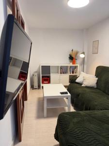a living room with a couch and a tv at Casa do medio in Corcubión