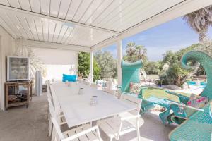 a dining room with a white table and chairs at Lointaines escapades in Perpignan