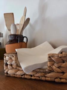 a basket with napkins and utensils on a table at Lakeview Jonny house on the roofs in Lezzeno