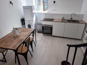 a kitchen with a wooden table with chairs and a sink at Le refuge bellifontain in Fontainebleau