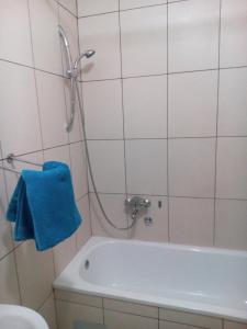 baño con bañera y toalla azul en Apartment Condor, en Tuzla