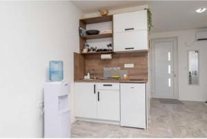 a kitchen with white cabinets and a sink at Apartmani Olga in Stari Bar +1 photo