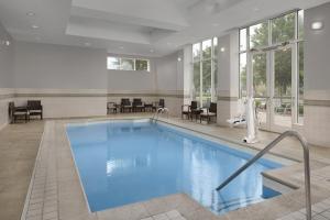 a pool in a hotel with chairs and tables at Holiday Inn Santee by IHG in Santee