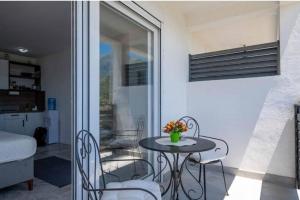 a small table and chairs in a room with a window at Apartmani Olga in Stari Bar
