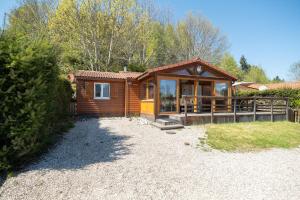 a log cabin with a porch and a fence at Chalet Le Sotré in Corcieux +17 photos