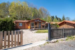 a wooden cabin with a fence in front of it at Chalet Le Sotré in Corcieux