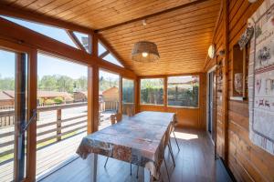 a dining room with a table in a room with windows at Chalet Le Sotré in Corcieux