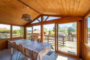 a dining room with a table and some windows at Chalet Le Sotré in Corcieux