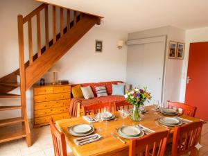 a dining room with a table and a couch at Chalet au lac de la raviège in La Salvetat