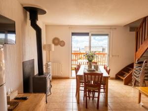 a dining room with a table and a wood stove at Chalet au lac de la raviège in La Salvetat