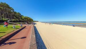 a view of a beach with people walking on it at Plage Pereire Arcachon vue sur mer in Arcachon +9 photos