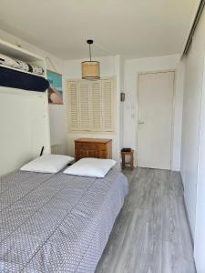 a bedroom with two beds and a wooden floor at Plage Pereire Arcachon vue sur mer in Arcachon
