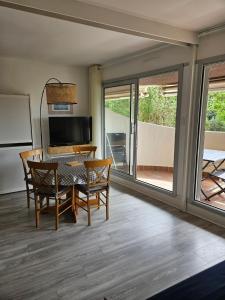 a dining room with a table and chairs and sliding glass doors at Plage Pereire Arcachon vue sur mer in Arcachon